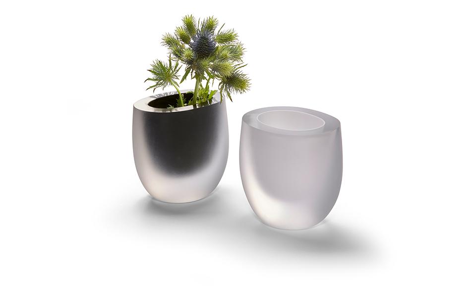 Ένα μαύρο και ένα λευκό βάζο Opak της Philippi με ένα άνθος στο μαύρο βάζο